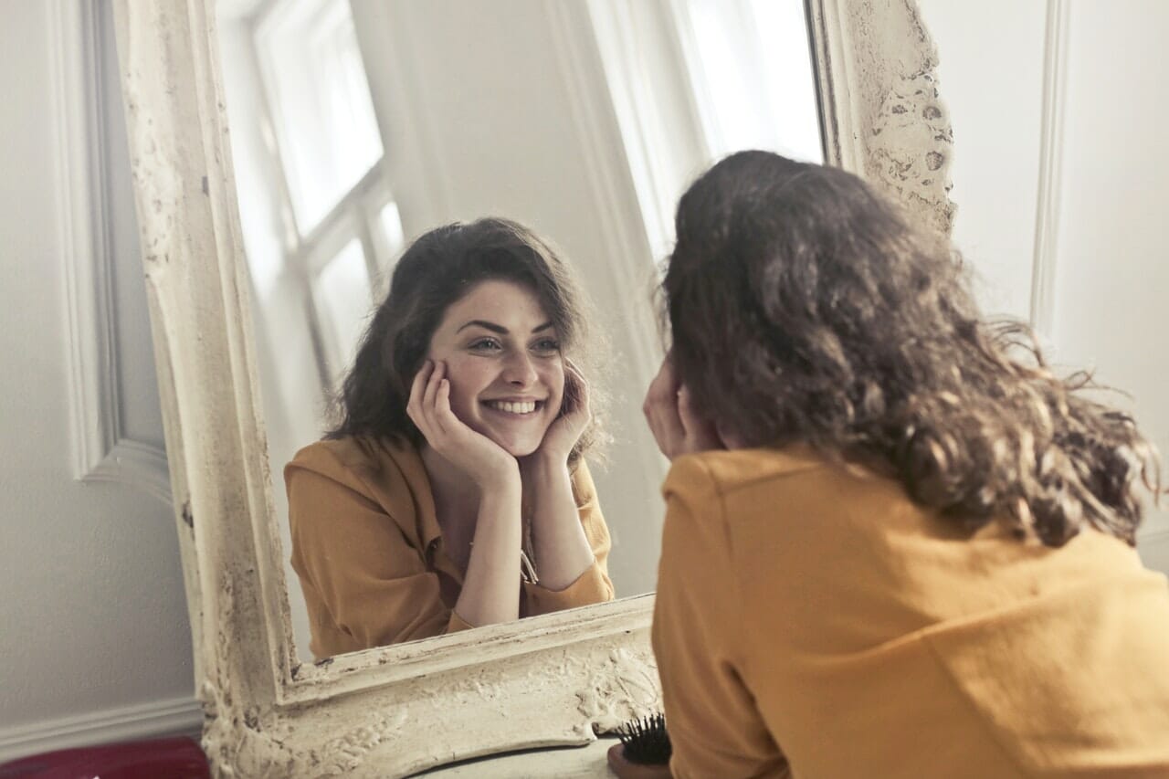 girl looking into a mirror smiling
