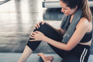 Close-Up of Pretty Woman Having Injury During Exercise in Gym While Yoga Practice, Accident and Sport Fitness Concept.
